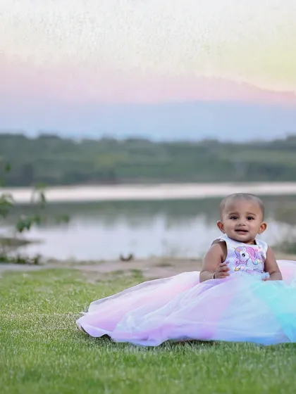 I love taking shoots outdoors, especially during the golden hour just before sunset. The natural light gives a magical feel to the photos, like this one of a little girl in her beautiful gown by the lake. I can travel to your preferred location in Bangalore.