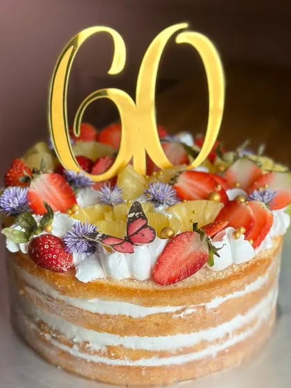 Berry sweet news! This fresh and fruity naked cake, topped with strawberries and pineapple, was the perfect way to celebrate a 60th birthday with natural elegance.