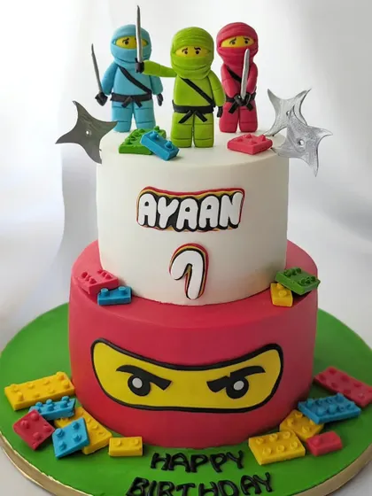 This two-tier Ninjago Lego cake is perfect for a 7th birthday. The bottom tier is a ninja's face, and the top is guarded by three fondant ninja warriors.
