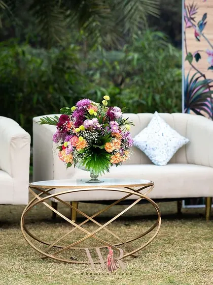 A lounge area with a custom-printed floral backdrop. The neutral sofas are accented with light blue cushions, picking up on the colors in the print and creating a fresh, coordinated look.