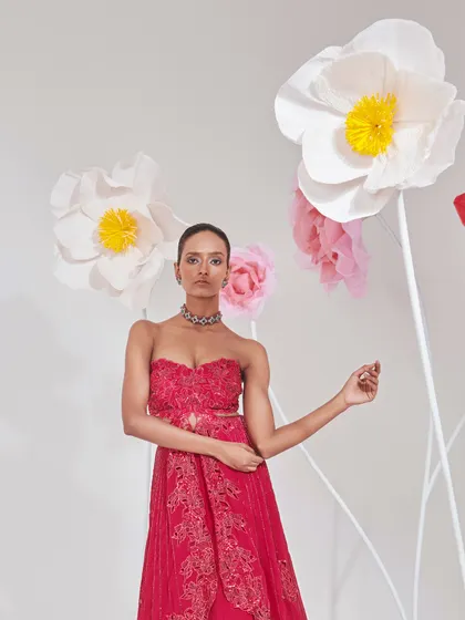 A strapless red gown with delicate embroidery, styled with a simple choker. The focus here is on the clean silhouette and the vibrant color.