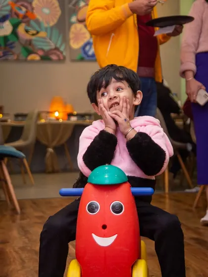 The look of pure delight while riding a smiley-faced toy. These simple moments of joy are what we're all about.