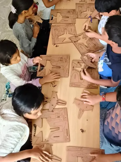 An overhead view of the intense concentration during our fighter jet building session. Every child is engaged in their own creation.