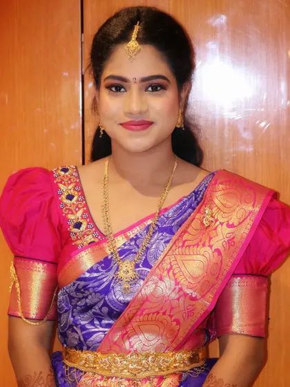 A simple and elegant look for the groom's sister. The makeup is natural and fresh, paired with a traditional puff-sleeve blouse and a beautiful silk saree, making her look perfect for an engagement ceremony.