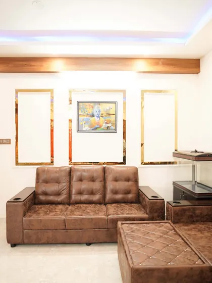 Another view of the living room with the brown leather sofa, showing the elegant wall treatment and the overall warm color scheme.