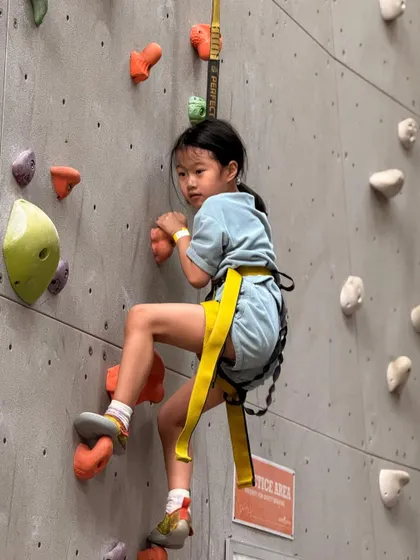 This young climber shows great technique as she navigates a challenging section of the wall. Our routes are designed to be engaging for kids of all skill levels.