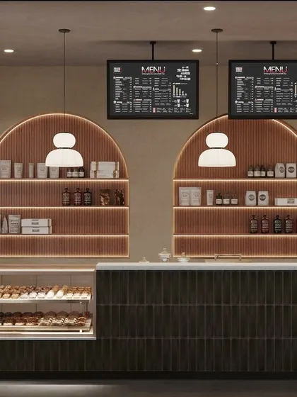 A cafe's counter is its engine. We designed this service area to be both beautiful and highly functional, with arched back-lit shelving for display, clear digital menu boards, and an efficient workflow for staff. The dark green tiles and warm wood tones continue the cafe's modern, earthy aesthetic.