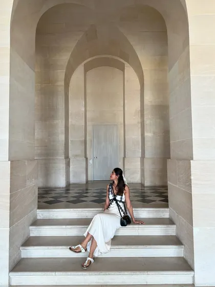Sitting on the steps inside the Palace of Versailles. The clean lines of the architecture contrast beautifully with the soft silhouette of my white and black lace dress.