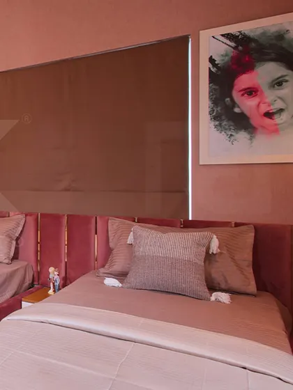 The sleeping area of the pink-themed kids' room, with custom portraits and cozy bedding.