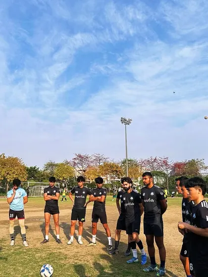 To be at the top, we have to climb every day. Our senior players listening intently to a coach during a training session, focused on continuous improvement.
