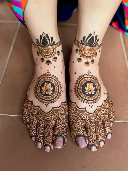 A wedding feet mehendi with a central lotus mandala and intricate detailing on the toes.