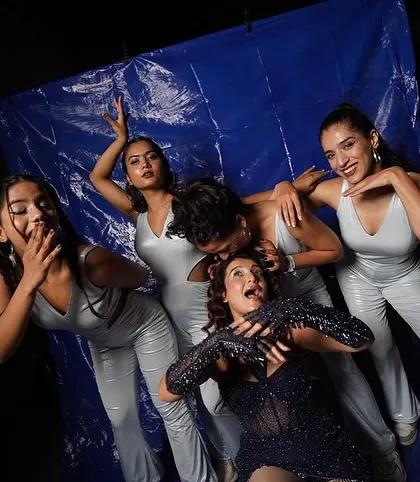 A fun, playful pose with the artist and dancers against a blue backdrop during a photoshoot for a show. Our team chemistry shines through both on and off the stage.