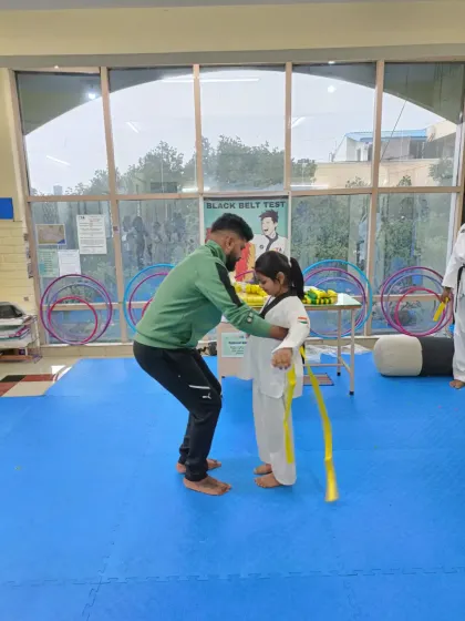 Tying a yellow belt for a young girl.