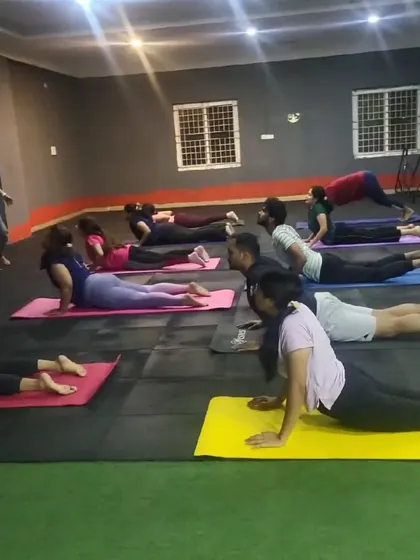 A group of members in cobra pose during a yoga class. This is a great backbend for strengthening the spine and opening the chest.