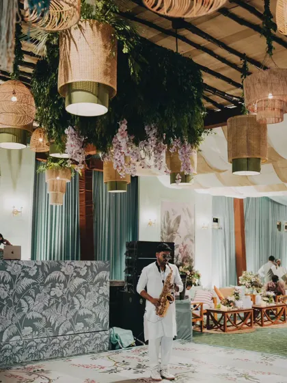A saxophonist sets a cool, relaxed vibe at a tropical-themed welcome soiree. I believe live music is essential for creating the right atmosphere for any event.