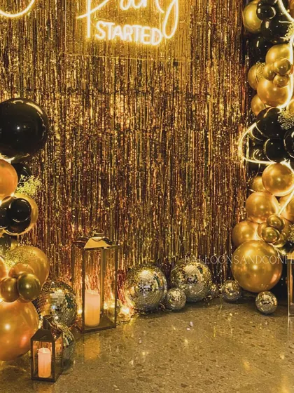 The base of our black and gold party setup. We used lanterns with LED candles and disco balls to fill the space and add extra layers of light and reflection.