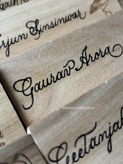 A detailed shot focusing on the precision of the calligraphy script on the wooden surface. Even on a challenging texture, the lettering remains crisp and elegant.