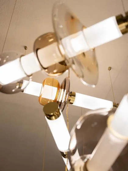 An upward view into a complex Luna chandelier installation captures the dynamic arrangement of its glowing tubes and glass forms. This perspective showcases the fixture's three-dimensional, sculptural quality.