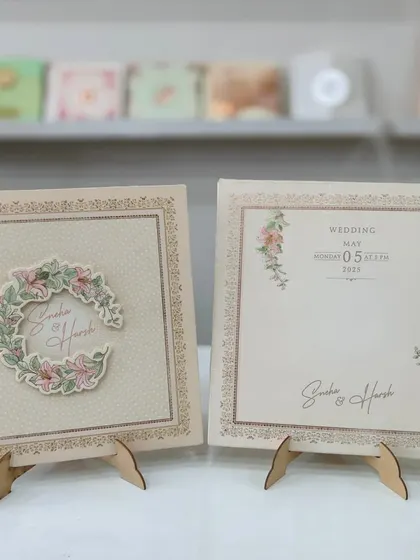 A beautiful pastel wedding invitation with a floral wreath design. This card is displayed in my showroom and is a popular choice for its elegant and affordable design.