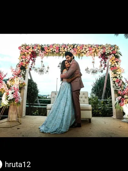 A beautiful sundowner engagement ceremony by the sea. We designed a stunning floral arch with pink and white roses, accented with hanging crystal chandeliers, to frame the couple against the ocean view.