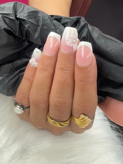 A classic French ombre look elevated with delicate 3D flowers and pearl accents. This is a perfect example of elegant and detailed nail art.