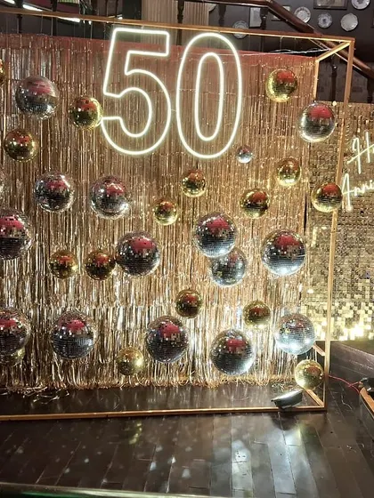 Another perspective of the grand 50th-anniversary installation. The structured frame adds a modern architectural element to the free-flowing glitter of the fringe and disco balls.