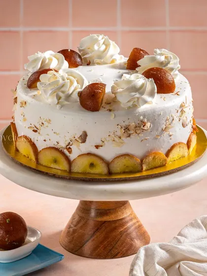 A modern take on a classic Indian dessert, this Gulab Jamun cake is topped with whipped cream and whole gulab jamuns.