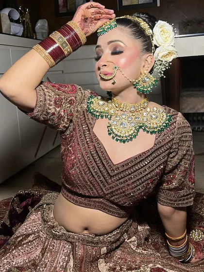 A playful pose from the bride, showing off her heavy jewellery and the detailed blouse of her rental lehenga.