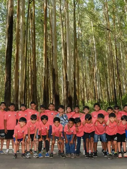 A picture-perfect moment. The entire team posing amidst the iconic Nilgiri trees on the way to Ooty.