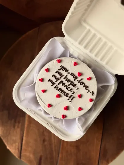 A heartfelt message on a simple white bento cake: "you, my love, my hope, my peace, my home!!" Surrounded by tiny red hearts, it’s a beautiful and personal declaration of love.