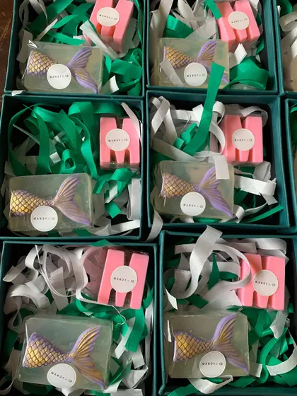 A unique mermaid gift set featuring a clear glycerin soap with an embedded mermaid tail and a personalized initial soap.