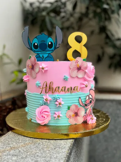 A tropical Stitch-themed cake for an 8th birthday. This fault line cake combines pink and turquoise buttercream, decorated with hibiscus flowers and Stitch characters.