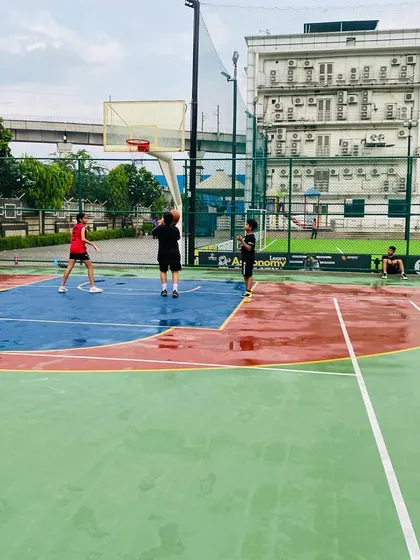 Players working on their game, with reflections on the wet court surface.