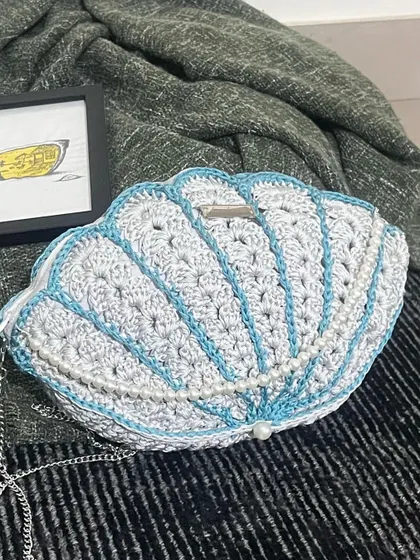 A different view of the Seashell Bag, showing the delicate silver chain and the detailed stitch work.