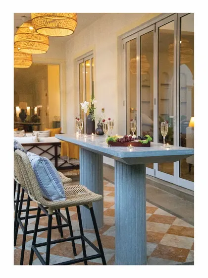 We designed this cast in-situ bar table in grey concrete for a verandah sit-out. Paired with cane bar chairs and matching hanging lights, it sets a relaxed yet sophisticated mood, perfect for enjoying drinks by the pool in this holiday home.