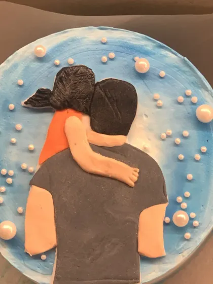 A heartfelt cake celebrating a father's love. The top features a handmade fondant design of a daughter hugging her dad.