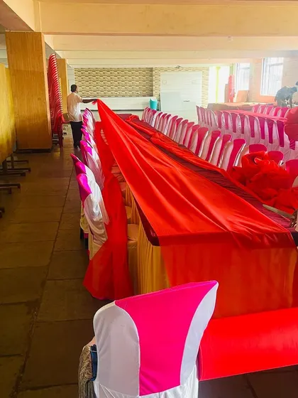 Our team laying down the red tablecloth for a Dastarkhwan setup. We take care of all the details, from the chair covers to the final table linens.