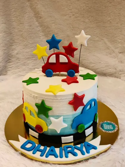 A simple and cute car-themed cake for a little one's birthday. The cake is decorated with colorful cars and stars, making it a cheerful and fun design.