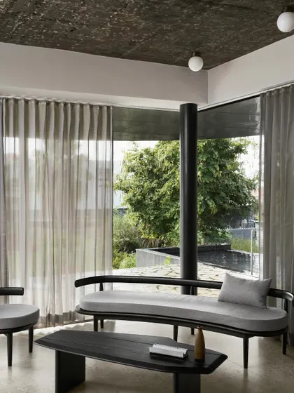 A duplicate of image 23, showing the living room of Pavilion House with its view of the pool and landscape.