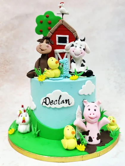 We bring the charm of the countryside to your party with this delightful farm animal cake. A classic red barn is surrounded by a friendly cow, horse, pig, and chickens, creating a vibrant and cheerful pastoral scene for a young child's birthday.