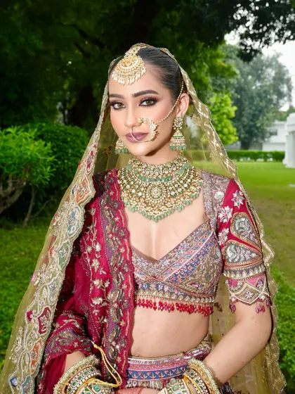 A stunning portrait of our bride, showcasing her regal makeup. The look features beautifully defined eyes, radiant skin, and is perfectly framed by her ornate dupatta and heavy bridal jewellery.