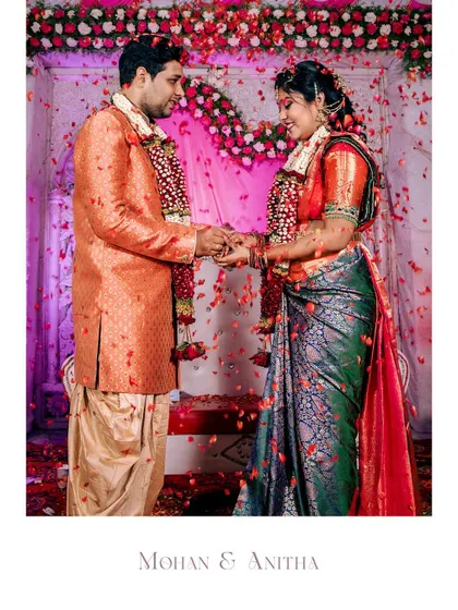 The moment of the ring exchange, with flower petals showering the happy couple. A perfect capture of a joyous celebration.