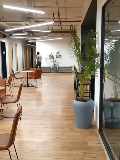 A casual seating area in the first VentureX office in India, located in Gurugram. This photo shows the open, inviting atmosphere we created with wood flooring, comfortable seating, and views into the glass-walled offices.