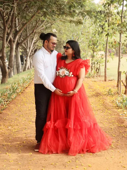 A beautiful outdoor portrait of the couple with their dog. The natural setting and their relaxed poses create a lovely, candid feel.