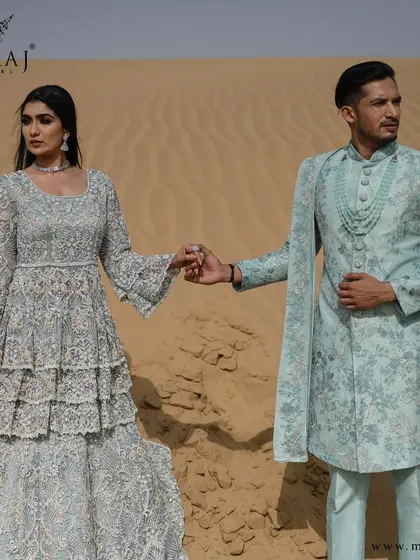 A complete vision of Indo-Western elegance. The groom's sea-green sherwani and the bride's matching tiered gown create a breathtaking picture of modern royalty, perfect for a destination wedding.