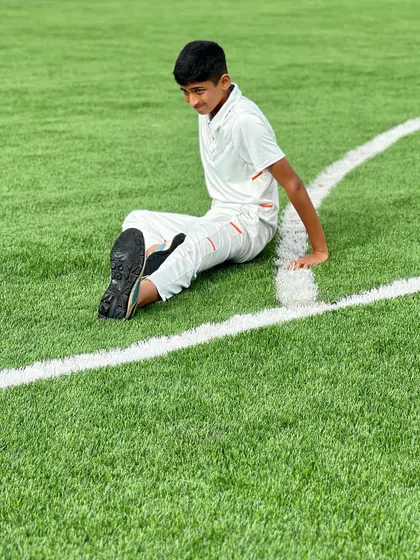 Taking a moment to rest and stretch on the field. I teach players the importance of listening to their bodies and properly recovering during and after training.