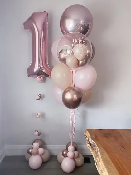 Celebrate a first birthday in style with this rose gold themed balloon arrangement. It includes a large number "1" foil balloon and a beautiful bunch of matching latex and chrome balloons.