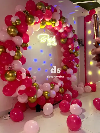 A behind-the-scenes look at our 'Bride to be' ring decoration. The setup includes a projector casting light spots, adding a dreamy effect to the pink and gold balloon arrangement.