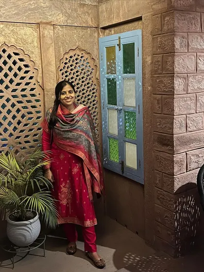 Standing next to a potted palm in a traditionally designed room. This shows how a single, well-placed plant can complement the architecture and bring a sense of life indoors.