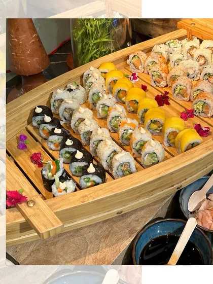 Another view of our stunning sushi boat, adorned with edible flowers. This presentation makes our sushi catering a true centerpiece for any luxe gathering.